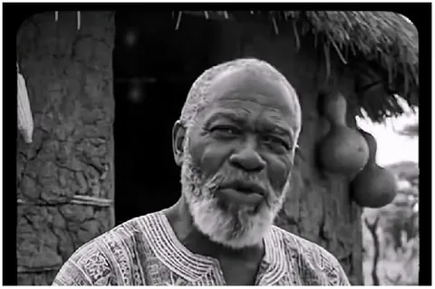 Bearded Man by Traditional Hut