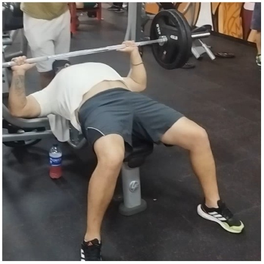Person Lifting Barbell in Gym