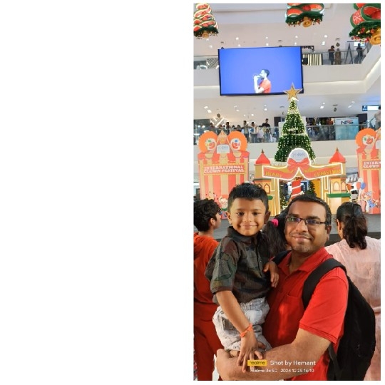 Man Holding Child by Christmas Tree