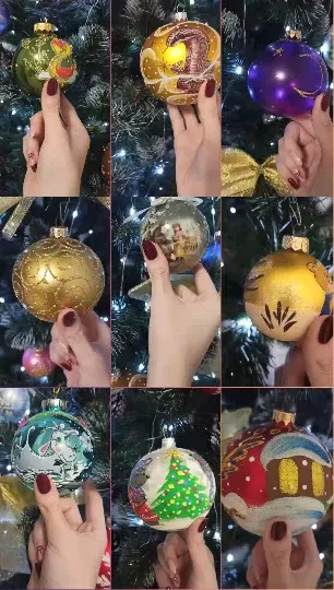 Hand Holding Christmas Ornaments on Tree