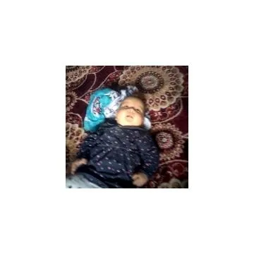 Baby on Patterned Blanket Surrounded by Pillows