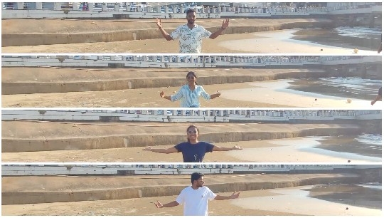 Individuals with Arms Outstretched on Beach