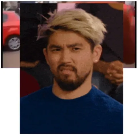 Blonde Man Scrunches Face by Car