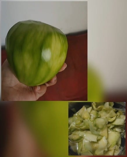 Hand Holding a Green Mango
