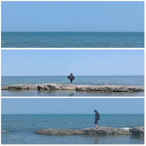 Person by Sea on Rocky Outcrop