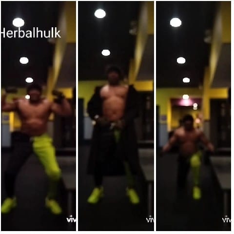 Flexing Muscles in Dim Gym