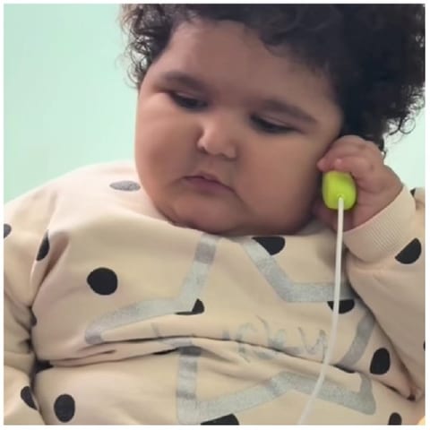 Child Listening to a Toy