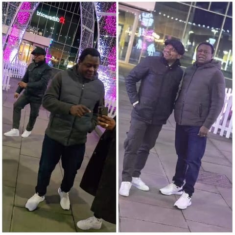 Two Men Under Festive Lighting