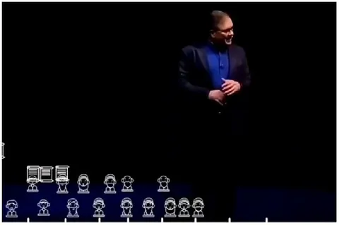 Man in Suit Speaking on Stage