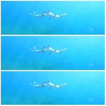 Two Swimmers Underwater in Blue Water