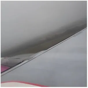 Airplane Wing Against Cloudy Sky